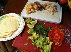 Red onion, tomato, cilantro, avocado, limes, seafood, and corn tortillas